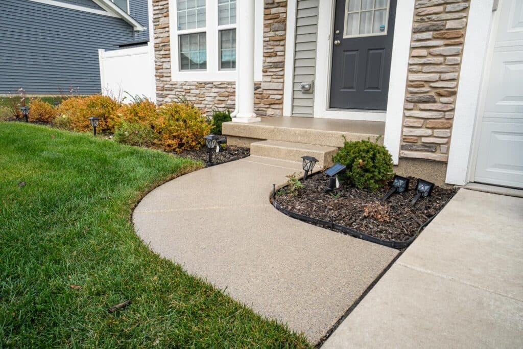 Durable epoxy coating applied to a front walkway and patio by Level 10 Coatings, enhancing outdoor aesthetics.