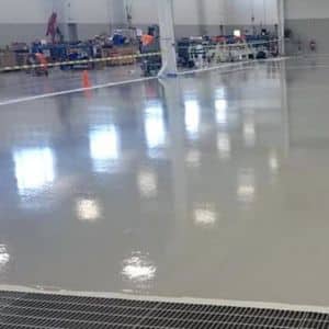 Polished dark gray concrete floor sprawling across a warehouse.